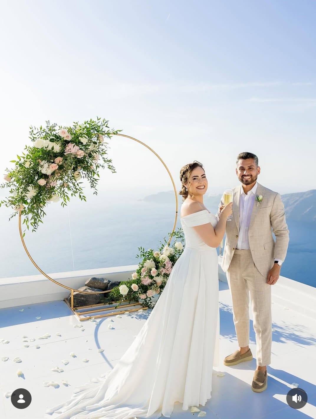 Wedding couple with floral arch and caldera view Santorini